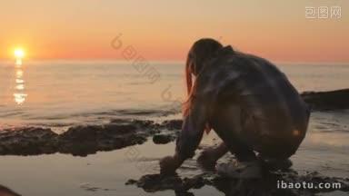 一个小女孩在海边用海水洗手洗脸